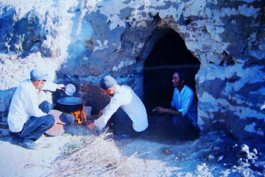 1983年，“六老漢”一代治沙人在“地窩子”生活做飯。新華社發(fā)（八步沙林場供圖）